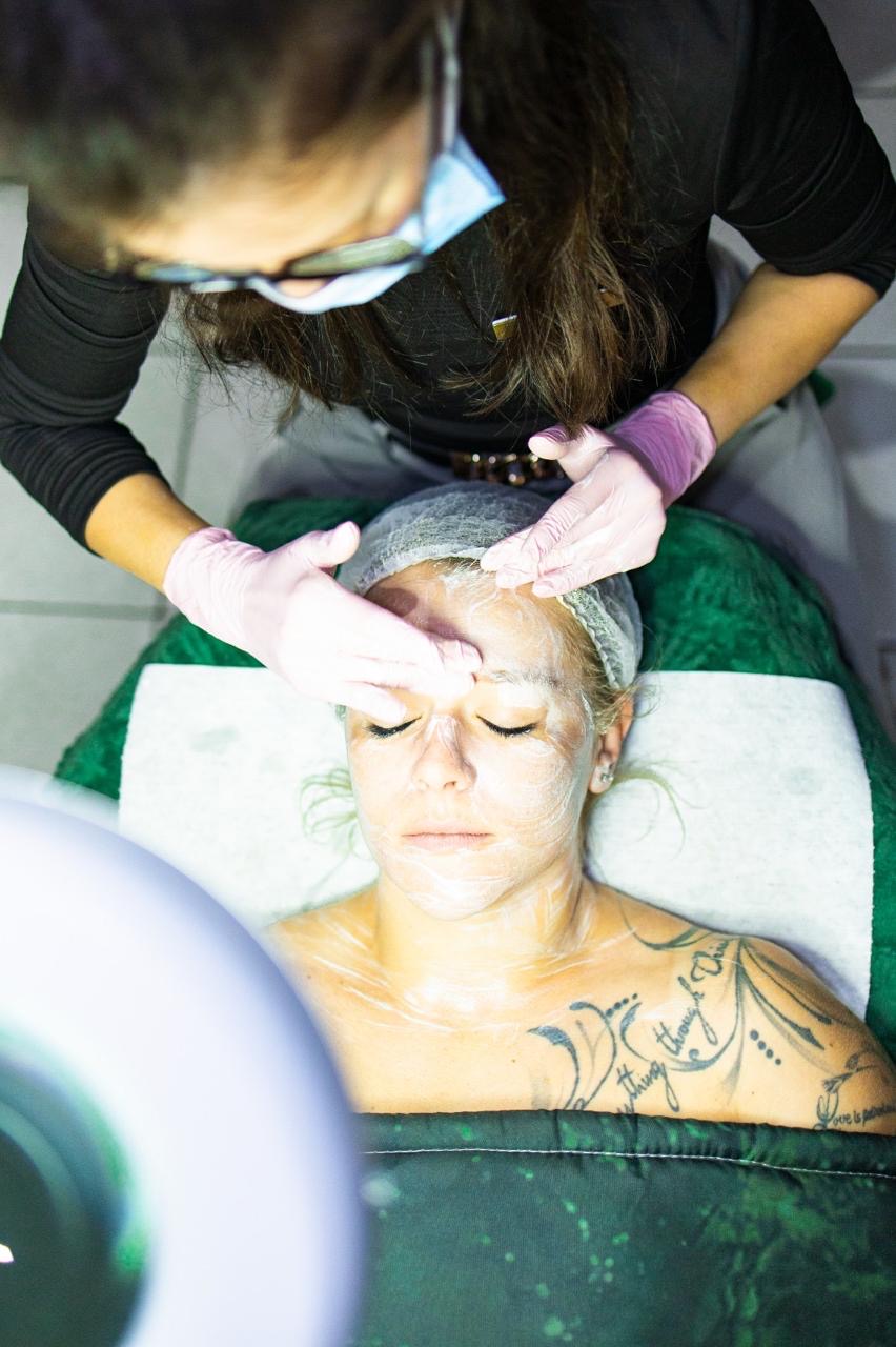 A practitioner providing facial care to a client